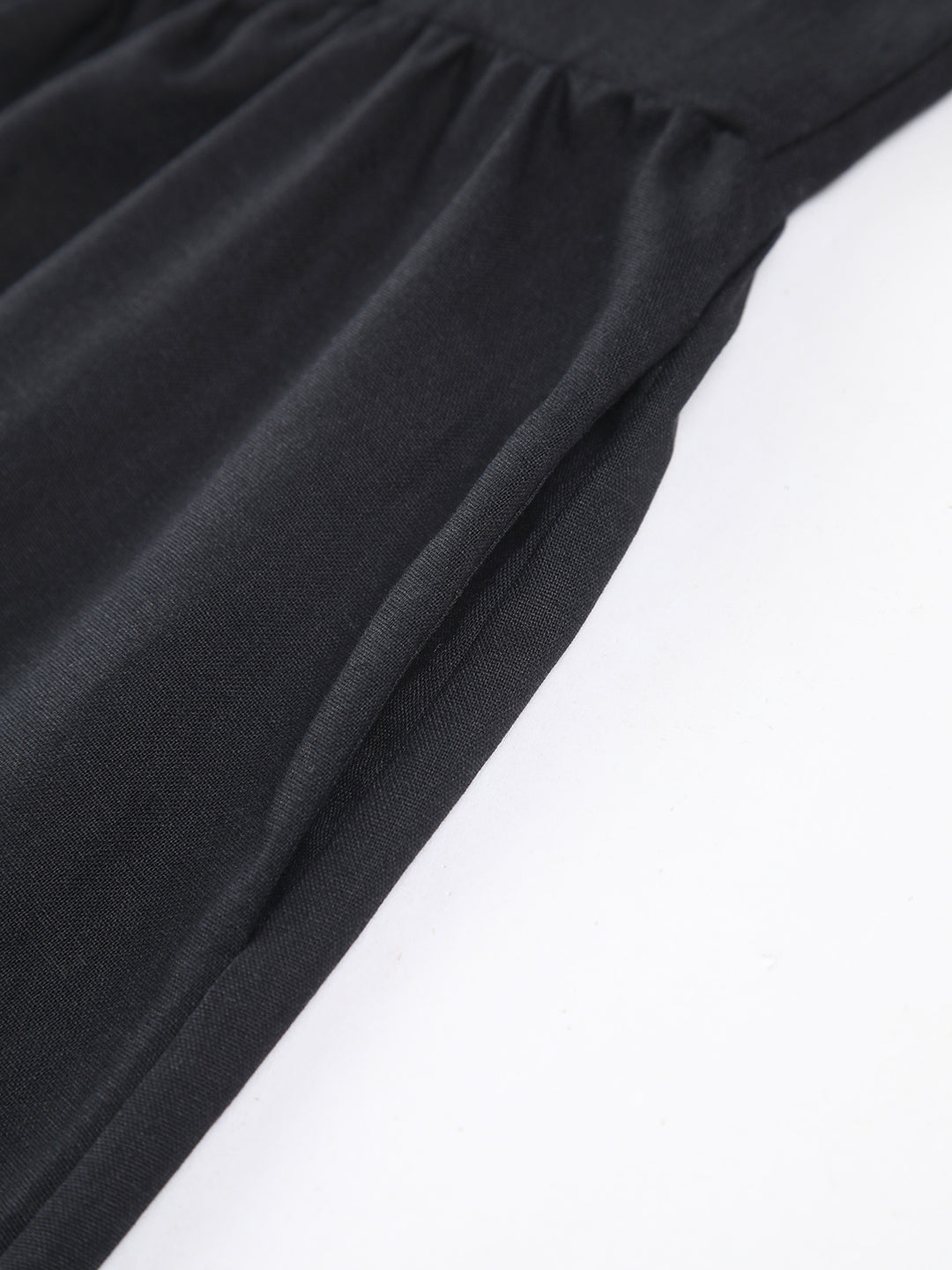 Svart klänning med markerad midja och rosettdetalj