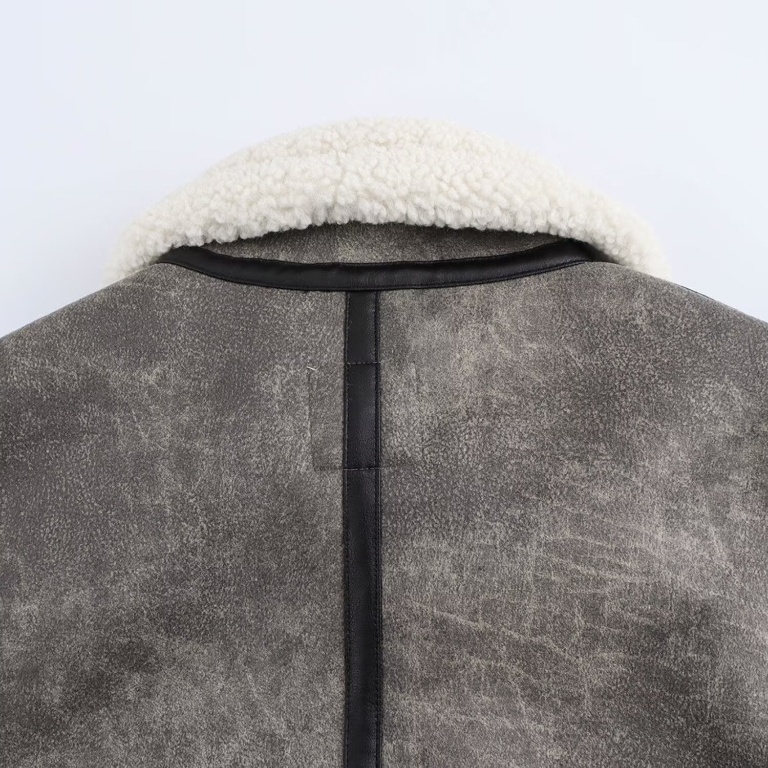 Kort jacka med ståkrage och spänndetaljer