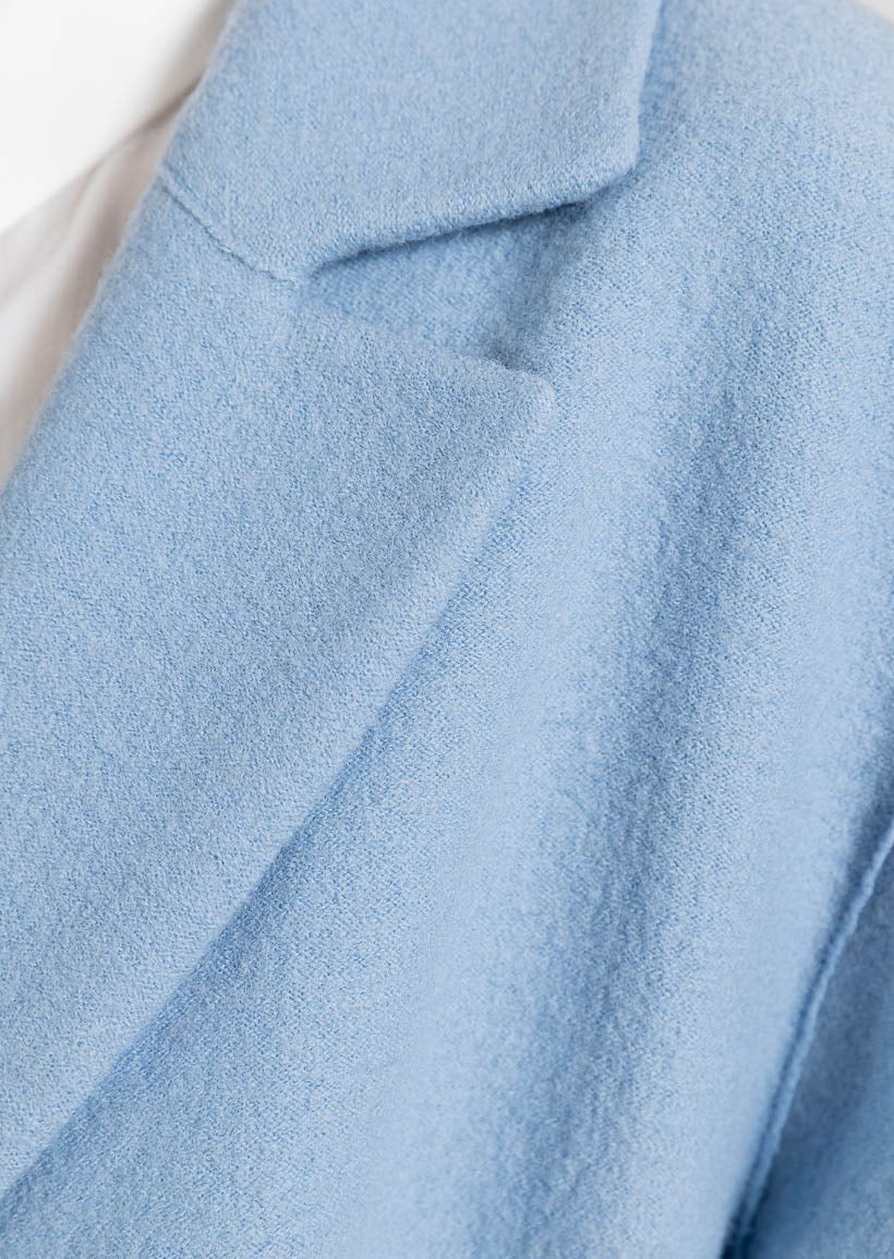 Ljusblå lång kappa med utanpåfickor