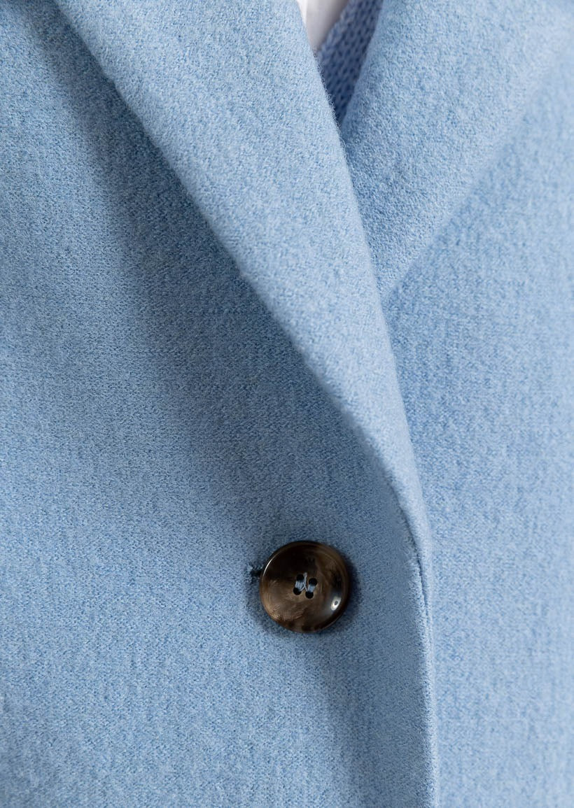 Ljusblå lång kappa med utanpåfickor